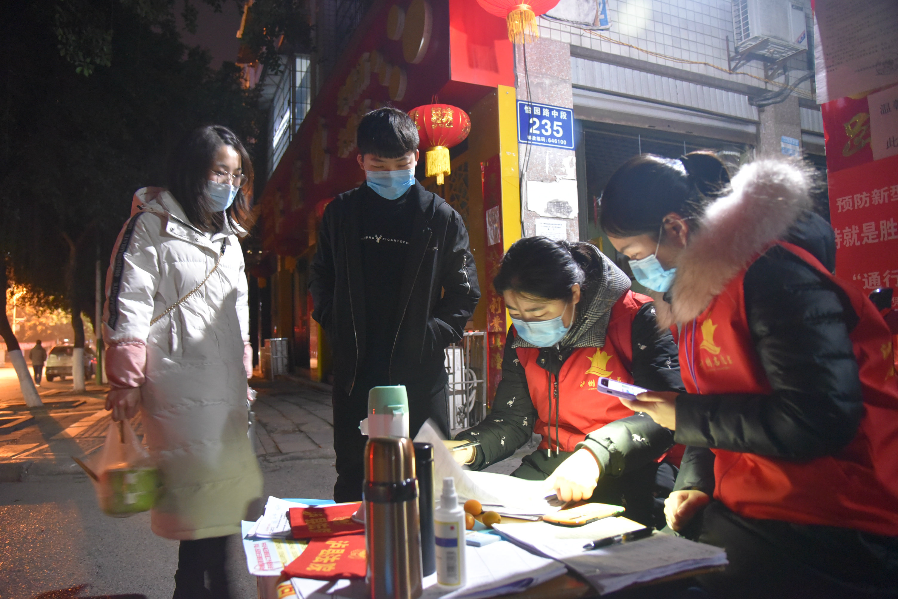 干警們查看小區居民出入證件.JPG