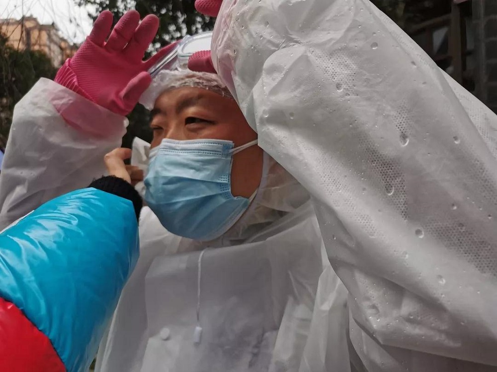 2月13日，青江街道辦事處轉業軍人牟海精剛完成一趟生活物資配送任務后，防護服就已被汗水全部浸濕。.jpg