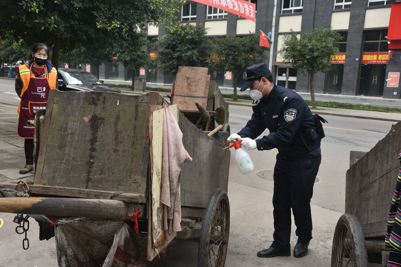 法警為進入小區(qū)的環(huán)衛(wèi)工人消毒 (2).JPG