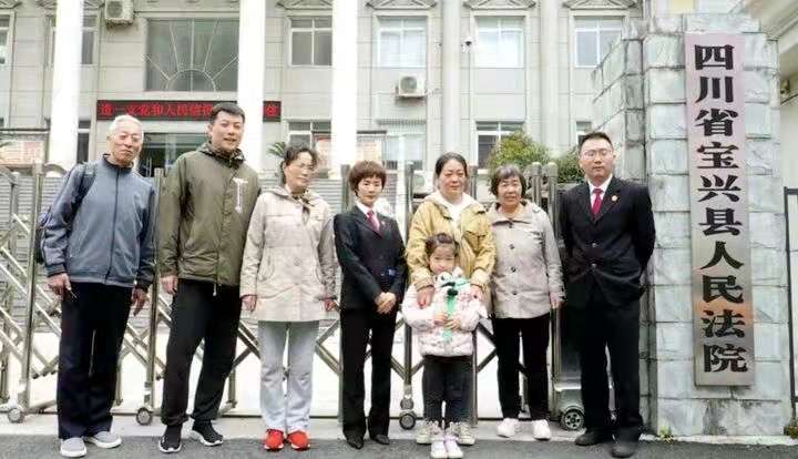 張志平老人一家與法院工作人員留影紀念.jpg