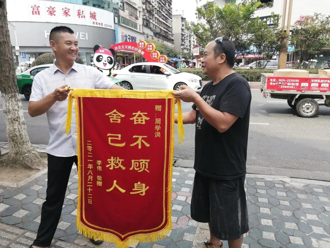 李偉（左）向周學(xué)洪贈(zèng)錦旗.jpg