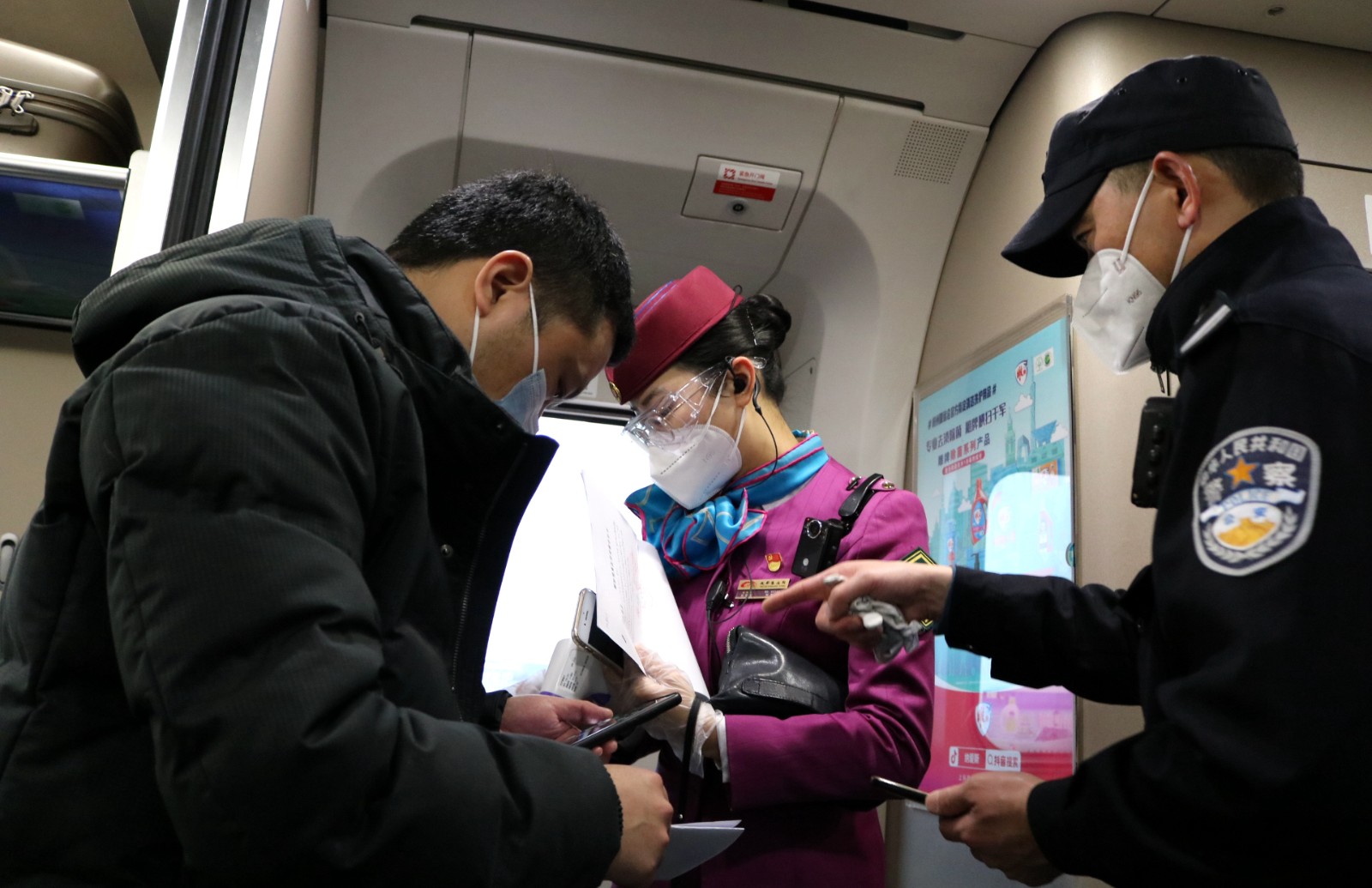 3乘警和車長共同核驗一名手續完備依規解除隔離人員的相關材料.JPG
