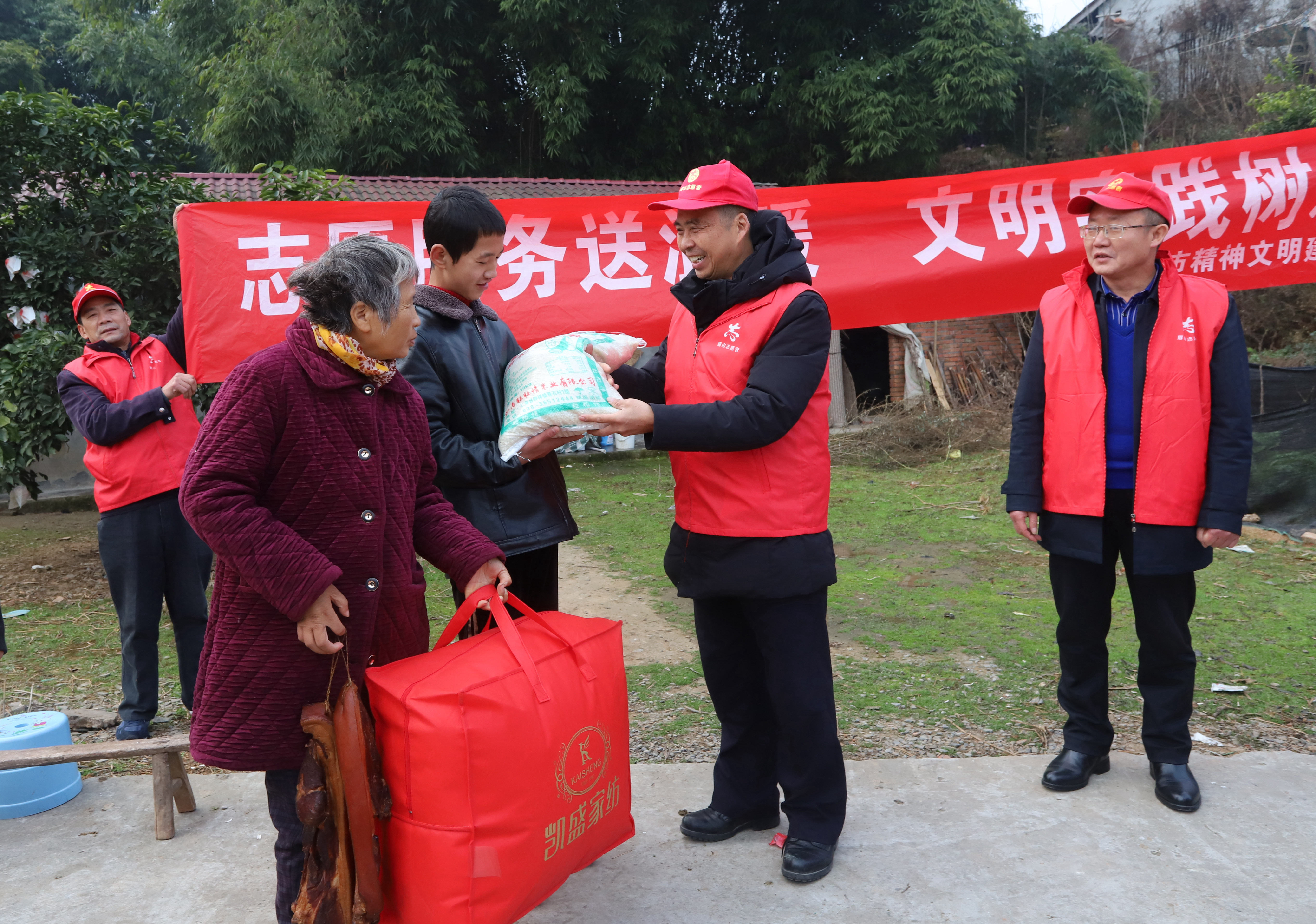 ４志愿者在為劉淑仙，張濤母子送被子，臘肉和大米。.JPG