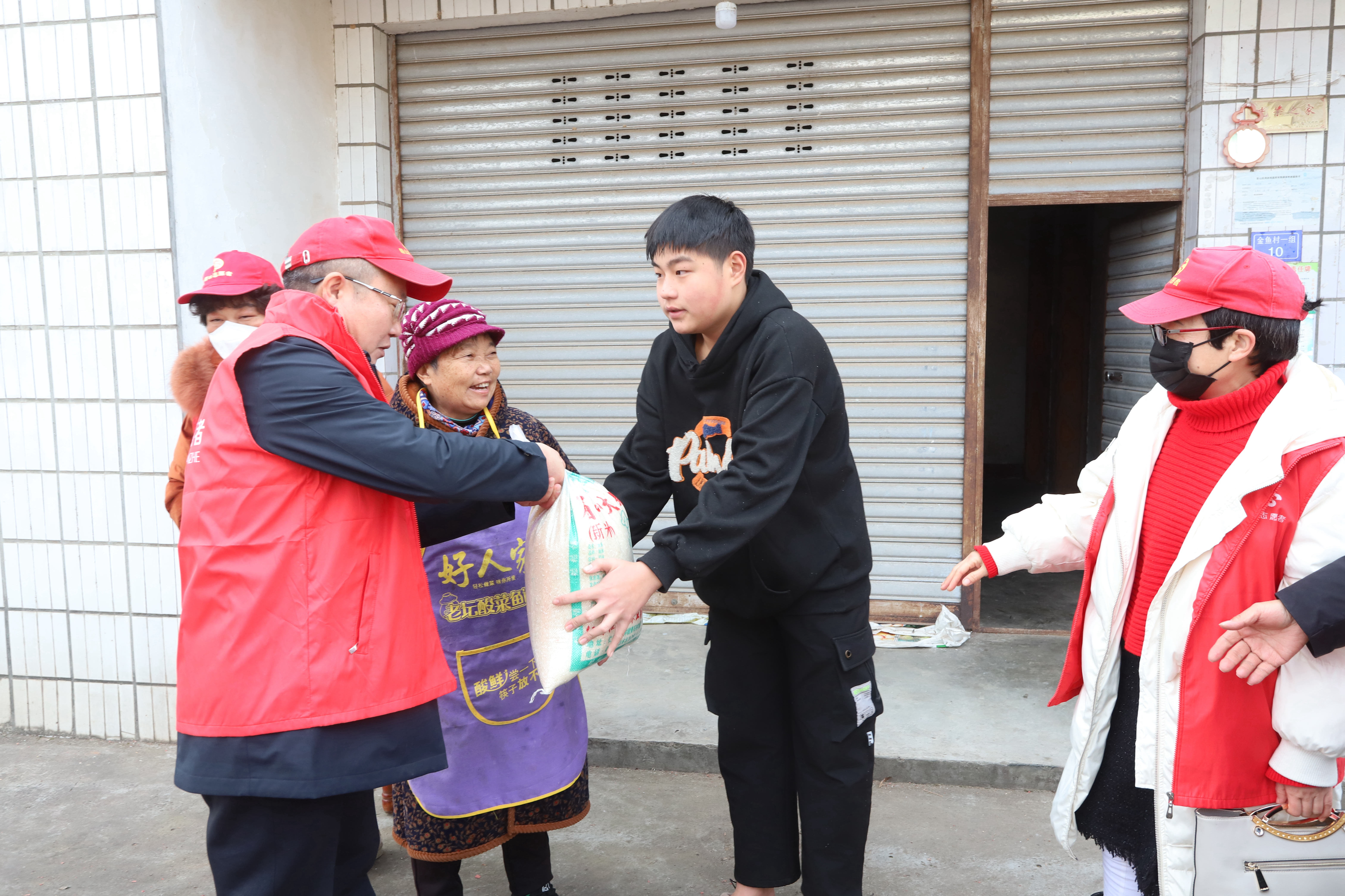 6.志愿者在為孤兒袁茂嬌送大米菜油等春節慰問品。.JPG