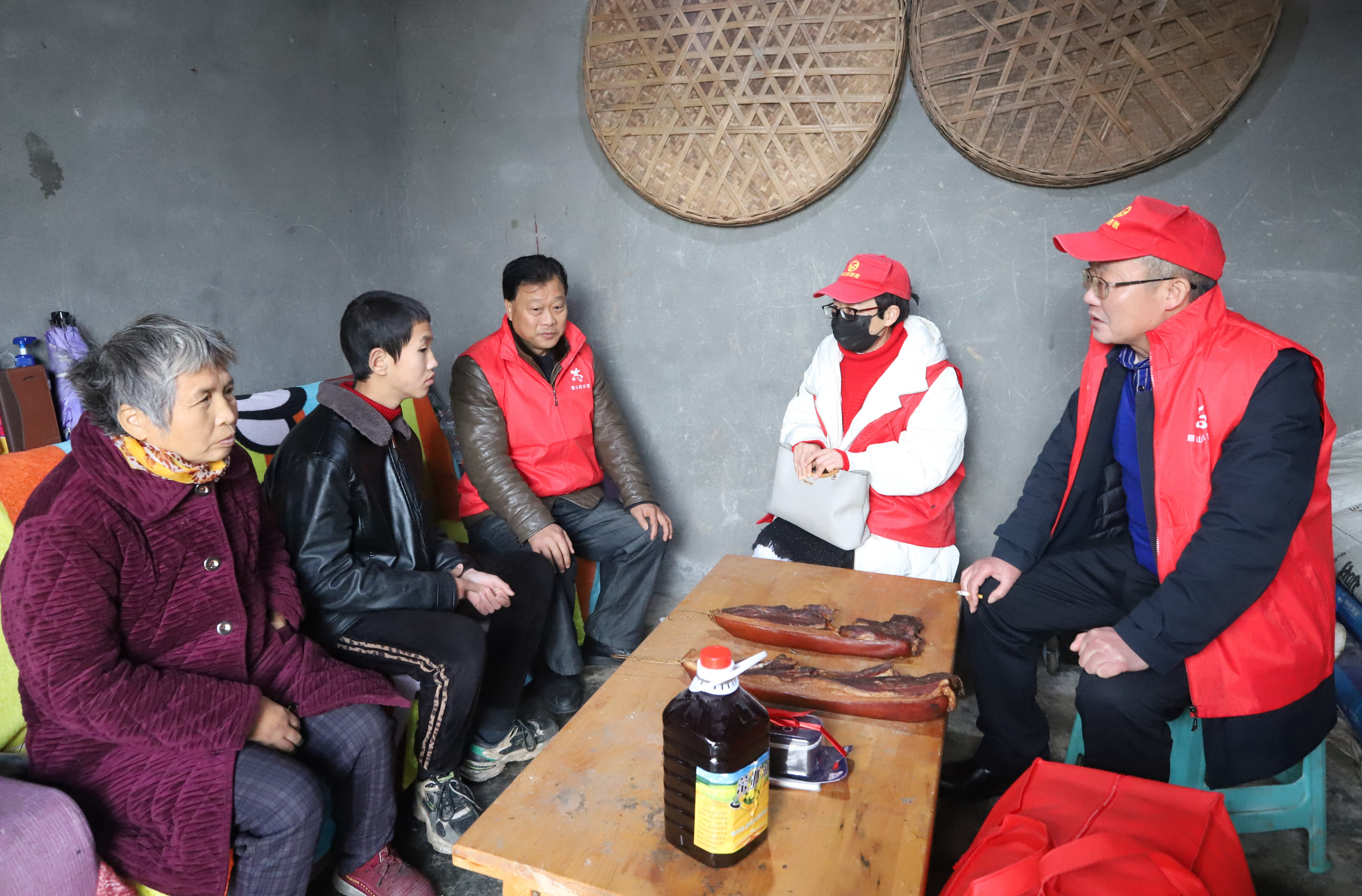 3志愿者在為劉淑仙，張濤母子送被子，臘肉，大米和菜油后親切交談。.JPG