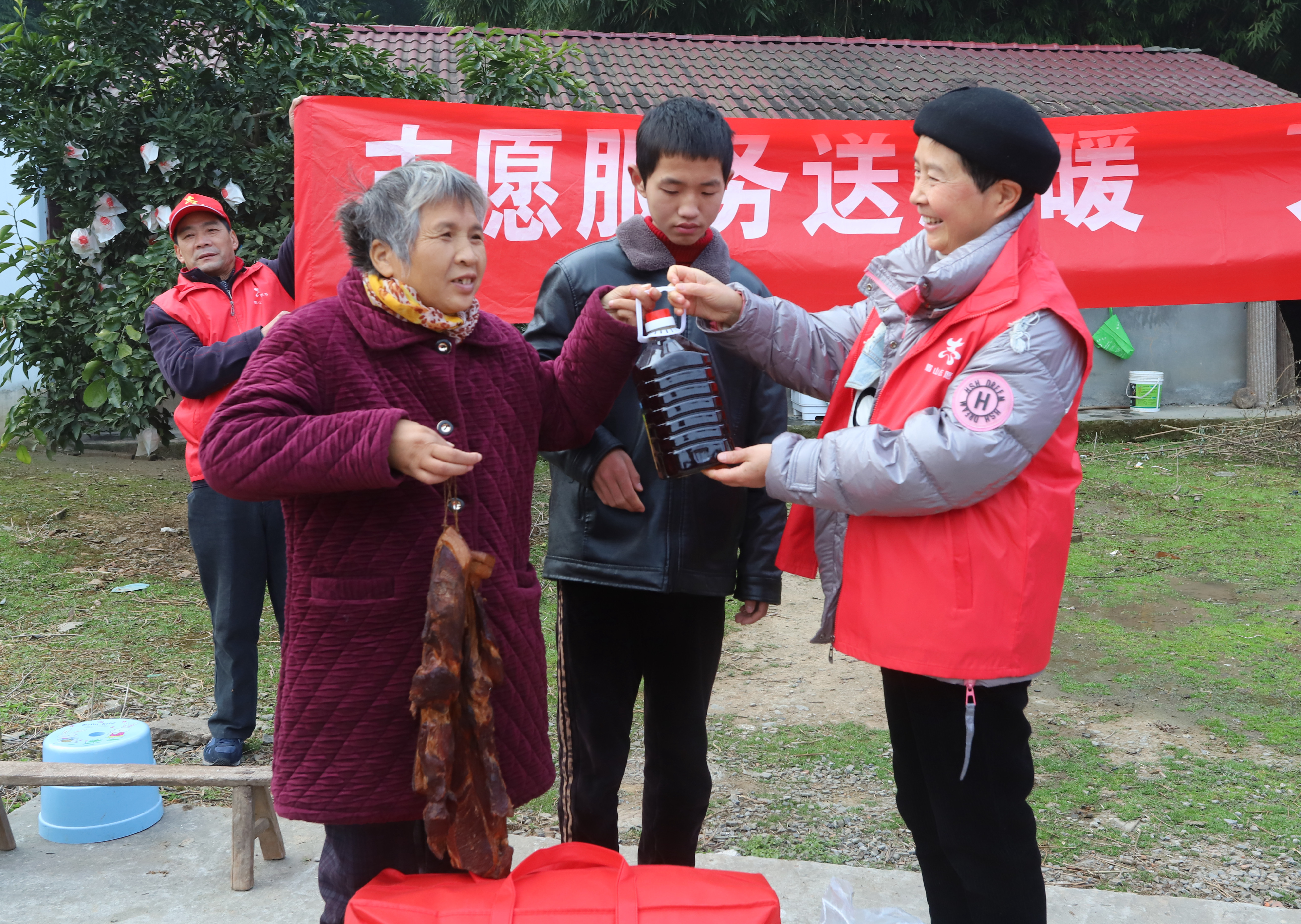 ５志愿者在為劉淑仙，張濤母子送被子，臘肉，大米和菜油。.JPG