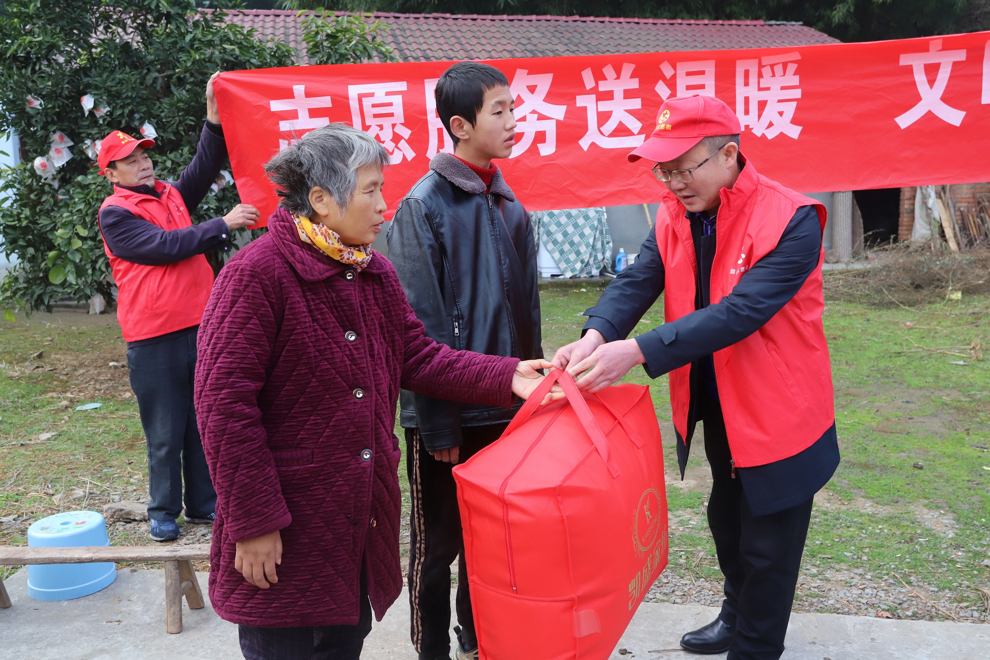 ３志愿者在為劉淑仙，張濤母子送被子。.JPG