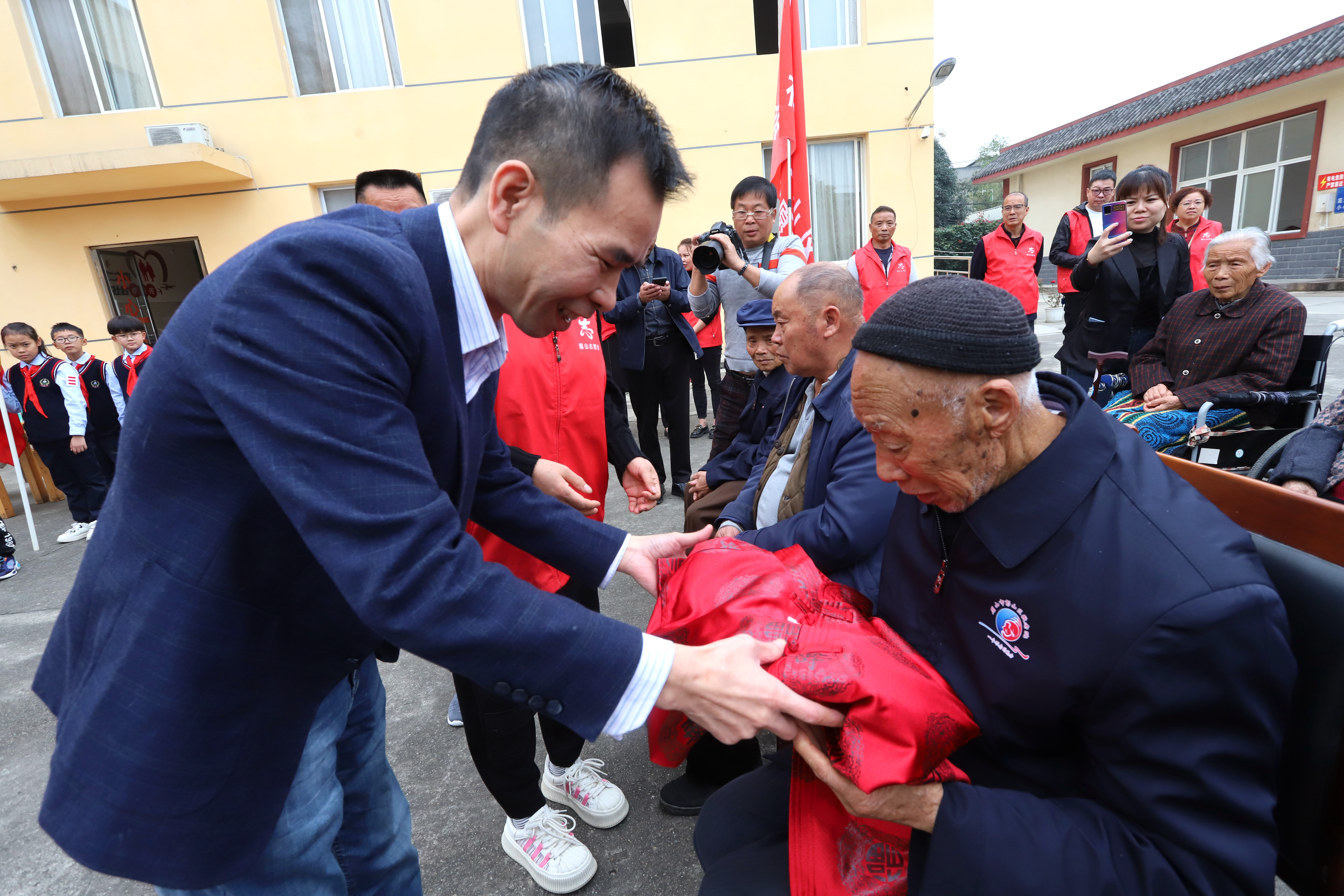 1志愿者為敬老院94歲老人送紅色壽字唐裝。.JPG