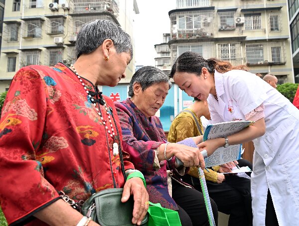 志愿者在便民義診現場發放健康資料.JPG